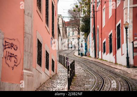 Lisbona, molto ripido tram di Gloria Restauradores. Graffiti sui mezzi pubblici e case colorate Foto Stock