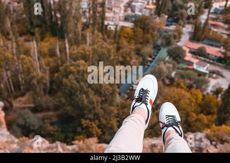 Giovane uomo turistico escursioni in cima alla collina. Concetto di escursione. Le gambe degli uomini si avvicinano sullo sfondo delle montagne Foto Stock