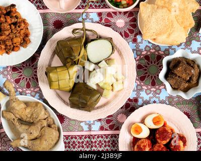 Ketupat Lebaran. Piatto tradizionale celebrativo di torta di riso o Ketupat con vari contorni, popolare servito durante le celebrazioni Eid. Foto Stock