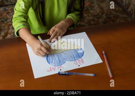 disegno dei bambini, bandiere dell'ucraina sono disegnate su un foglio, le mani dei bambini tengono un cuore fatto, guerra fra i paesi, concetto di pace Foto Stock