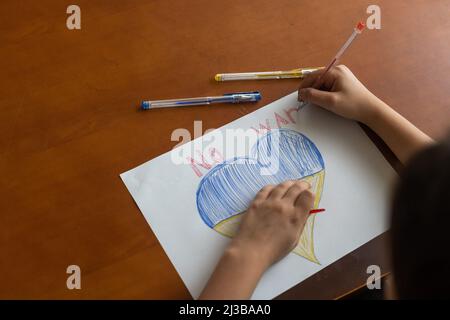 disegno dei bambini, bandiere dell'ucraina sono disegnate su un foglio, le mani dei bambini tengono un cuore fatto, guerra fra i paesi, concetto di pace Foto Stock