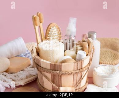 Secchio per sauna con cosmetici naturali biologici e accessori riutilizzabili per la cura della pelle e dei capelli su rosa. Primo piano della produzione ecologica di bellezza Foto Stock