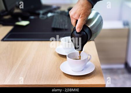 Man versare il caffè nella tazza Foto Stock
