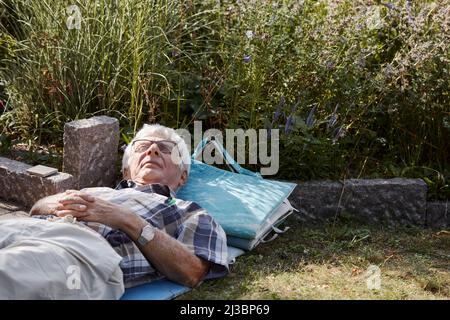 Uomo anziano che si rilassa sul prato Foto Stock