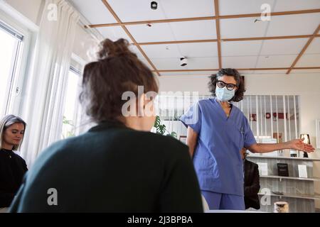 Medico parlando di pazienti in sala di attesa Foto Stock