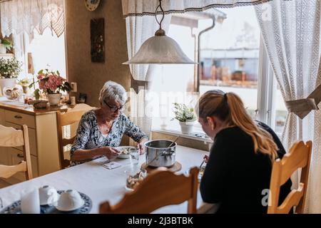Nonna e nonna adulta che mangiano a casa Foto Stock