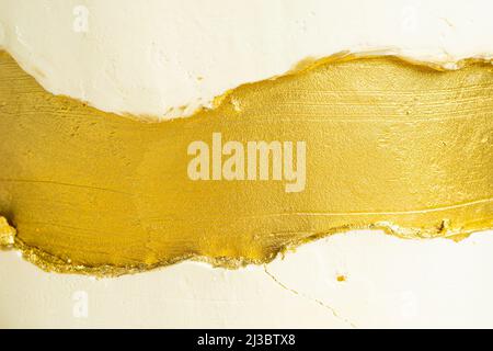 Vista macro di crema dorata e bianca sulla torta. Decorazioni per torte con spruzzi d'oro. Consistenza della torta. Foto di alta qualità Foto Stock