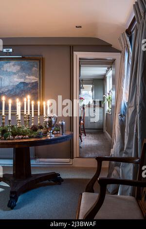 Candele accese sul tavolo in 18th secolo Suffolk cottage a Natale, Regno Unito Foto Stock