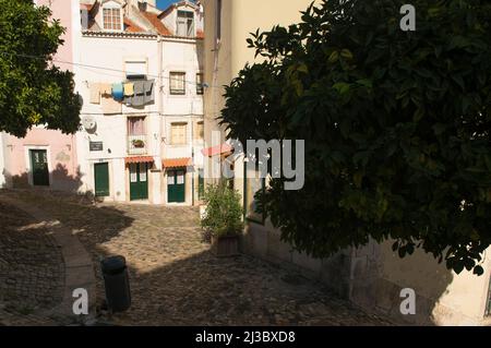 In parte ombreggiato vicolo acciottolato nel quartiere Alfalma con lavanderia a secco, Lisbona, Portogallo Foto Stock