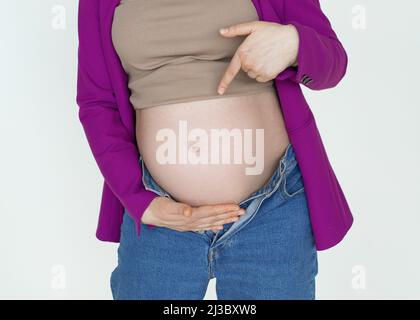 Primo piano, gravidanza ventre donna incinta mostrare dito, donna incinta irriconoscibile bambino in attesa, giovane madre felice Foto Stock