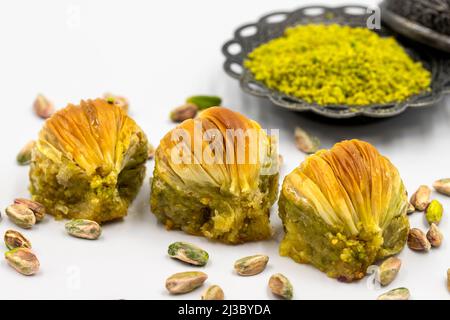 Cozze baklava su sfondo bianco. Specialità della cucina mediterranea tradizionale. Primo piano pistacchio baklava. Nome locale midye baklava Foto Stock