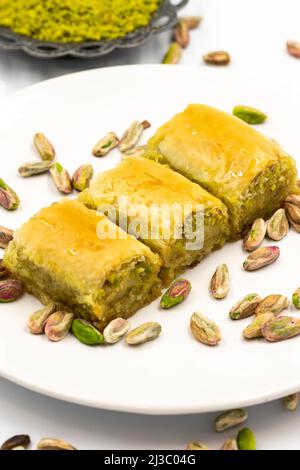 Baklava con pistacchio su sfondo bianco. Specialità della cucina mediterranea tradizionale. Primo piano baklava Foto Stock