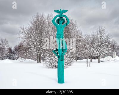 Mosca. Russia. Aprile 3, 2022. Una scultura verde di un ragazzo con un uccello in mano sullo sfondo di un parco coperto di neve. Foto Stock