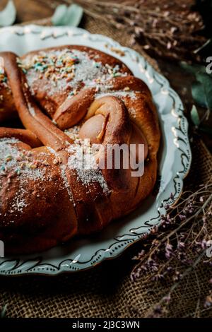 Primo piano di una tradizionale mona de pascua, una torta consumata il lunedì di Pasqua in Spagna, ornata con uova sode, zucchero e spolverini di diversi co Foto Stock