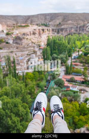 Le gambe degli uomini si avvicinano sullo sfondo delle montagne. Giovane uomo turistico escursioni in cima alla collina. Concetto di escursione. Foto Stock