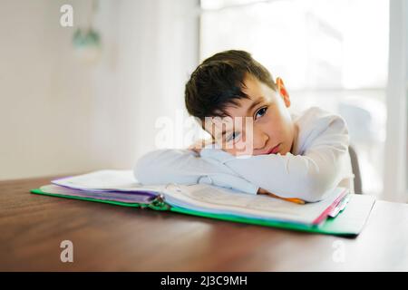 Il bambino pensante annoiò e frustrato e si stanche facendo i suoi compiti Foto Stock