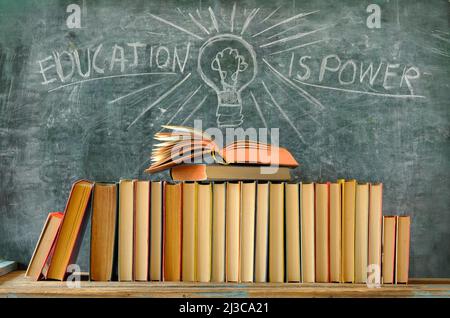 Libro aperto, fila di libri e lavagna con disegno di una lampadina e slogan istruzione è potere, apprendimento, istruzione, ritorno a scuola concetto Foto Stock