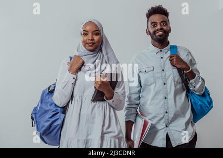 Giovani studenti africani coppia camminando donna indossando tradizionale sudanese musulmano abiti hijab squadra di affari isolato su sfondo bianco. Alta qualità Foto Stock