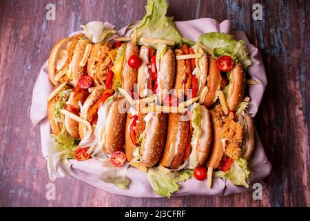 Hamburger diversi visti dall'alto con patatine fritte nel mezzo dei sandwich. Cesti con un panno sotto gli hamburger. Foto Stock