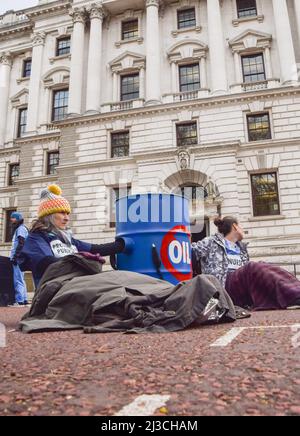 Londra, Inghilterra, Regno Unito. 7th Apr 2022. I manifestanti si sono bloccati in un barile. Estinzione i medici della ribellione e gli operatori sanitari hanno bloccato la strada al di fuori del Tesoro HM a Westminster la Giornata Mondiale della Sanità, in protesta contro il finanziamento del governo di combustibili fossili. Diversi manifestanti si sono incollati a barili. (Credit Image: © Vuk Valcic/ZUMA Press Wire) Foto Stock