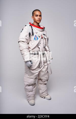 Corpo pieno di astronauta maschio colombiano in uniforme pronto per indagare il cosmo in piedi in studio e guardare la macchina fotografica Foto Stock