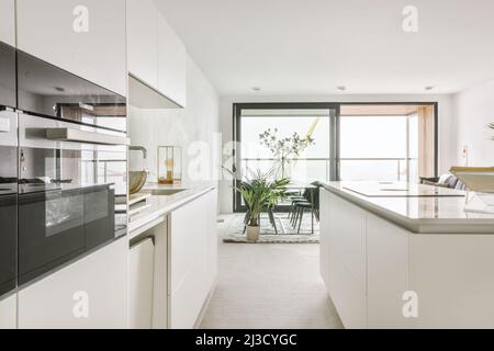 Forni moderni con superficie lucida integrati in armadi in cucina in stile minimal Foto Stock