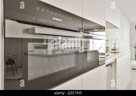 Forni moderni con superficie lucida integrati in armadi in cucina in stile minimal Foto Stock