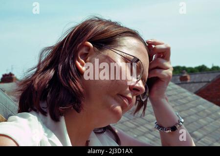donna che beve al sole Foto Stock