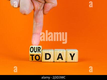 Oggi è il nostro simbolo del giorno. L'uomo d'affari trasforma il cubo di legno e cambia le parole di concetto oggi al nostro giorno. Bellissimo sfondo arancione, spazio copia. Autobus Foto Stock