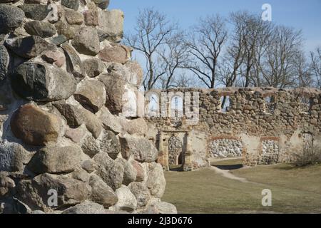 Un muro di pietra delle rovine del castello in primo piano in vista su uno sfondo di un luogo storico del medievale 14th secolo. Rovine del castello di Dobele, Lettonia Foto Stock