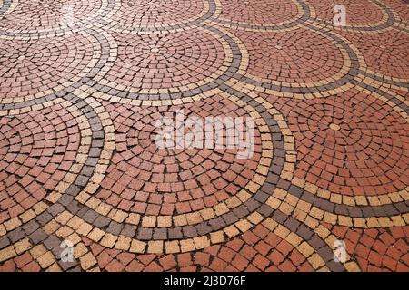 pietre di pavimentazione marroni disposte in cerchi, vista prospettica Foto Stock