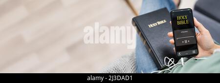Donna ascoltando la Bibbia audiolibro sullo smartphone Foto Stock