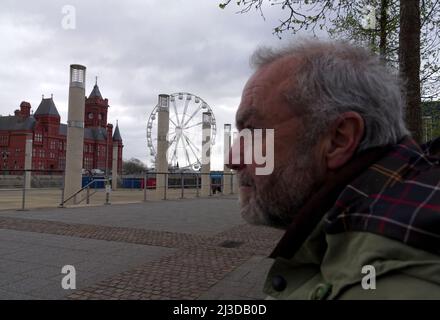 Una rara foto del fotografo di paesaggio Graham Bell senza la sua macchina fotografica a Cardiff Bay con una ruota panoramica e il Pierhead Building sullo sfondo Foto Stock