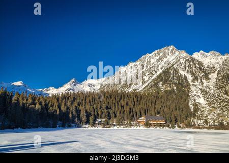 Paesaggio di montagna con ghiacciato tarn in stagione invernale. Il lago Popradske pleso nel Parco Nazionale degli alti Tatra, Slovacchia, Europa. Foto Stock