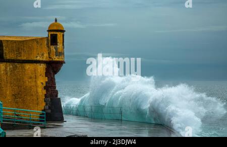 Onde che si infrangono di fronte al Forte di São Tiago situato nel centro storico di Funchal, Madeira. Foto Stock