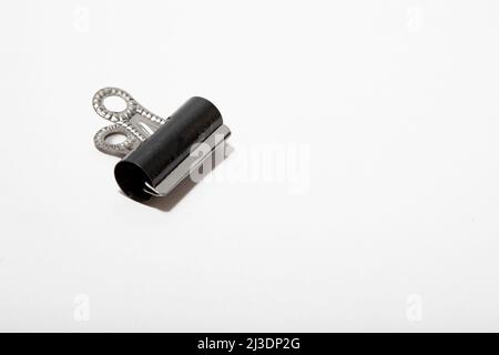 un primo piano di un singolo bulldog clip su uno sfondo bianco nessuna gente nessuno Foto Stock