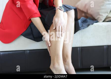 Giovane donna che soffre di dolore alle gambe a casa closeup Foto Stock