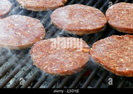 hamburger di carne di manzo su una griglia di barbecue affumicato caldo Foto Stock