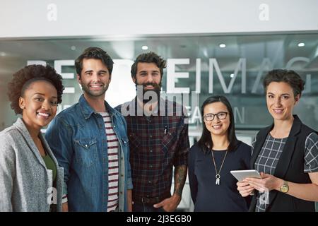 Chiamaci il tuo team di sogno. Ritratto ritagliato di un gruppo di uomini d'affari creativi in piedi nel loro ufficio. Foto Stock
