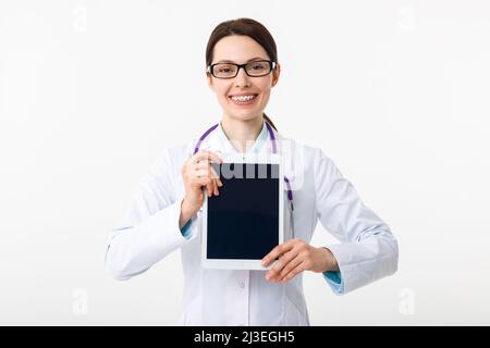 Ragazza allegra dottore che tiene in mano un portadocumenti e punta al copyspace con un gesto Foto Stock