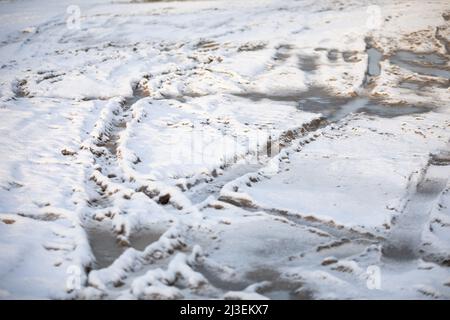 Tracce di solchi auto su strada sterrata coperta di neve. Foto Stock