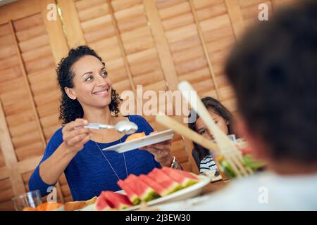 Il suo gustoso e nutriente. Un colpo di una famiglia felice si è riunito intorno al loro tavolo per un pasto. Foto Stock