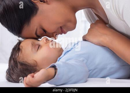 Ritratto di madre carezzando il bambino addormentato con affetto Foto Stock