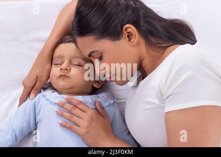 Ritratto di madre carezzando il bambino addormentato con affetto Foto Stock