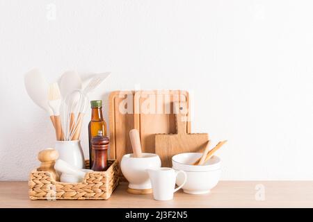 articoli ecologici di utensili moderni su un piano di lavoro in legno da cucina vicino a una parete bianca testurizzata. materiali ecologici senza plastica Foto Stock