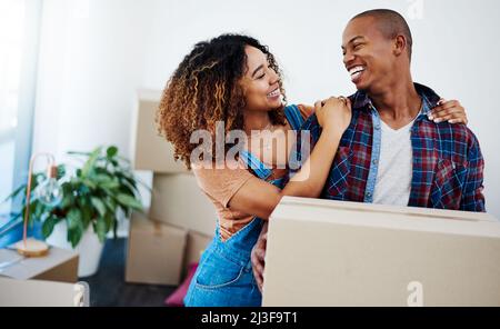 Non guardare avanti con voi indietro. Scatto di una bella casa in movimento giovane coppia. Foto Stock