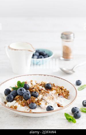 Ciotola di granola con mirtillo fresco, formaggio caserma o curd, yogurt e noci. Cibo sano. Colazione Foto Stock