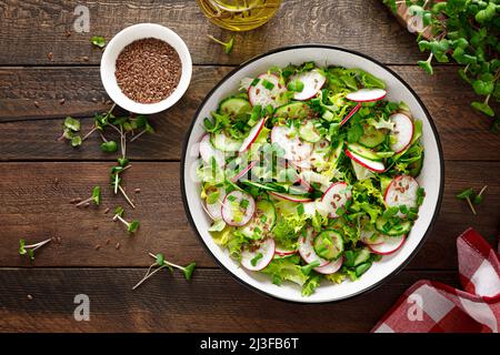 Insalata di ravanelli e cetrioli con cipolla verde fresca in ciotola, vista dall'alto Foto Stock