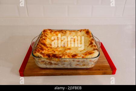 Lasagne in stile italiano tradizionale con carne macinata e formaggio fuso. Cotto in una teglia rotonda. Isolato. Piatto fuoco selettivo Foto Stock