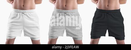Mockup di pantaloncini bianchi, neri, in erica sciolti con linea di compressione sul corpo atletico maschio, isolato sullo sfondo. Imposta. Modello di abbigliamento con sottobosco Foto Stock